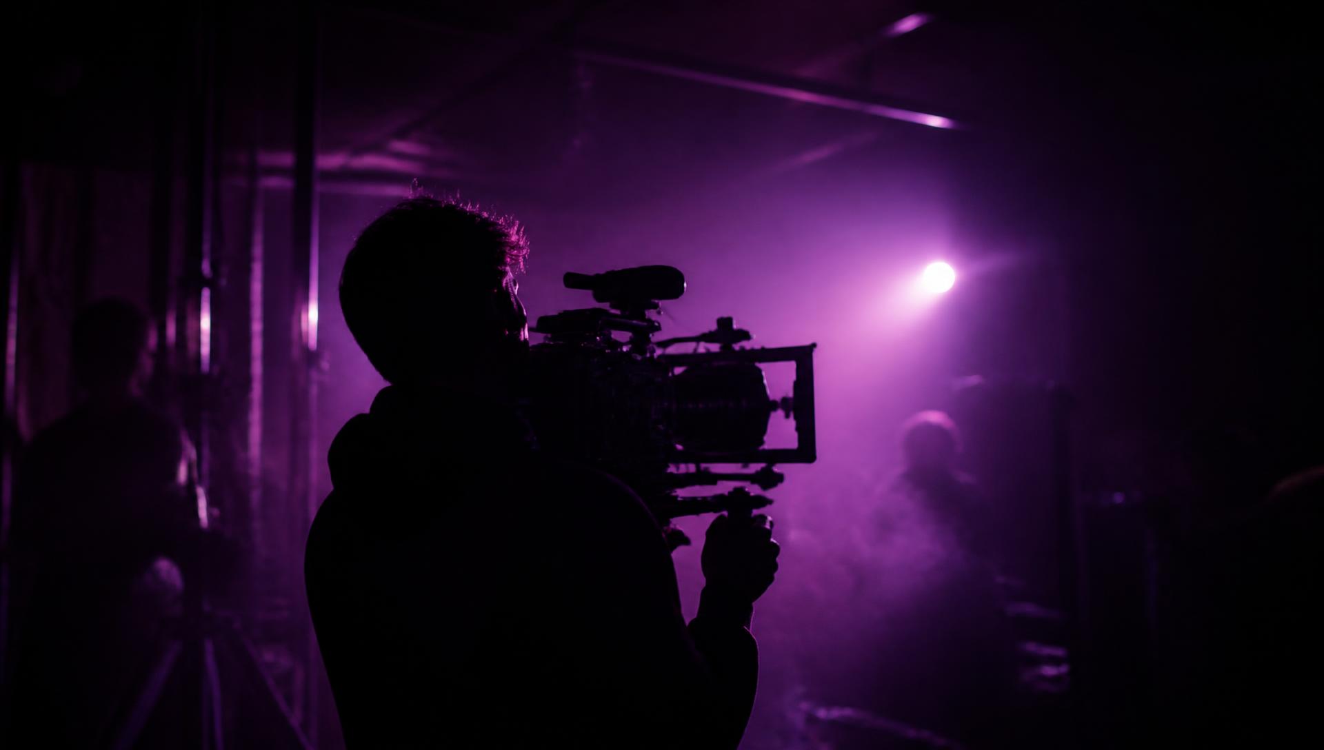 FILMERA crew shooting on a dark set lit with brand purple light